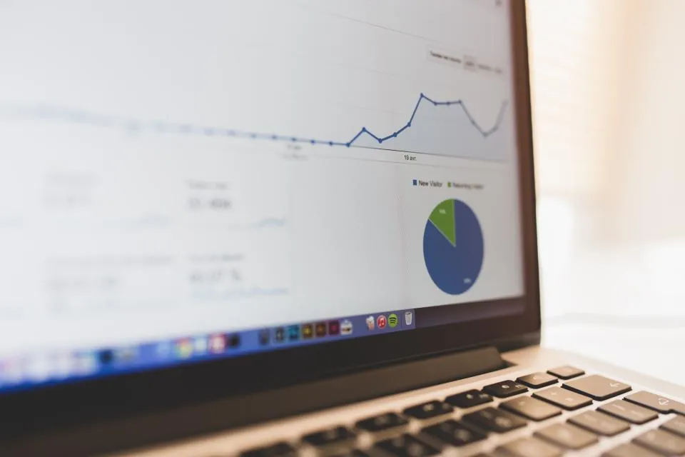 A laptop showing an analytics dashboard with charts