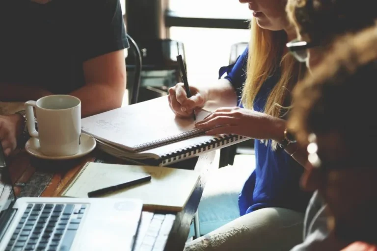 A team around a table with notebooks and laptops, planning