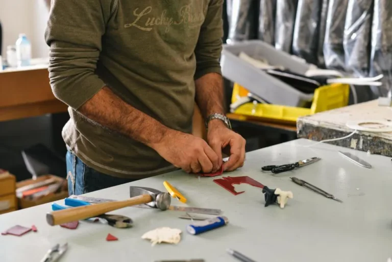 A person at a workbench surrounded by hand tools