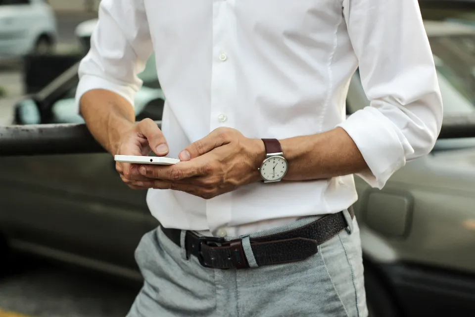 A businessman in a white shirt using his smartphone