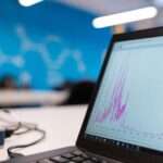 Laptop displaying a data analytics graph in a modern office, representing predictive analytics for SMEs